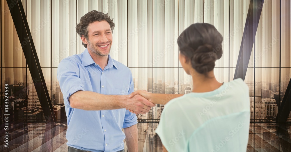 Male and female colleagues shaking hands in office