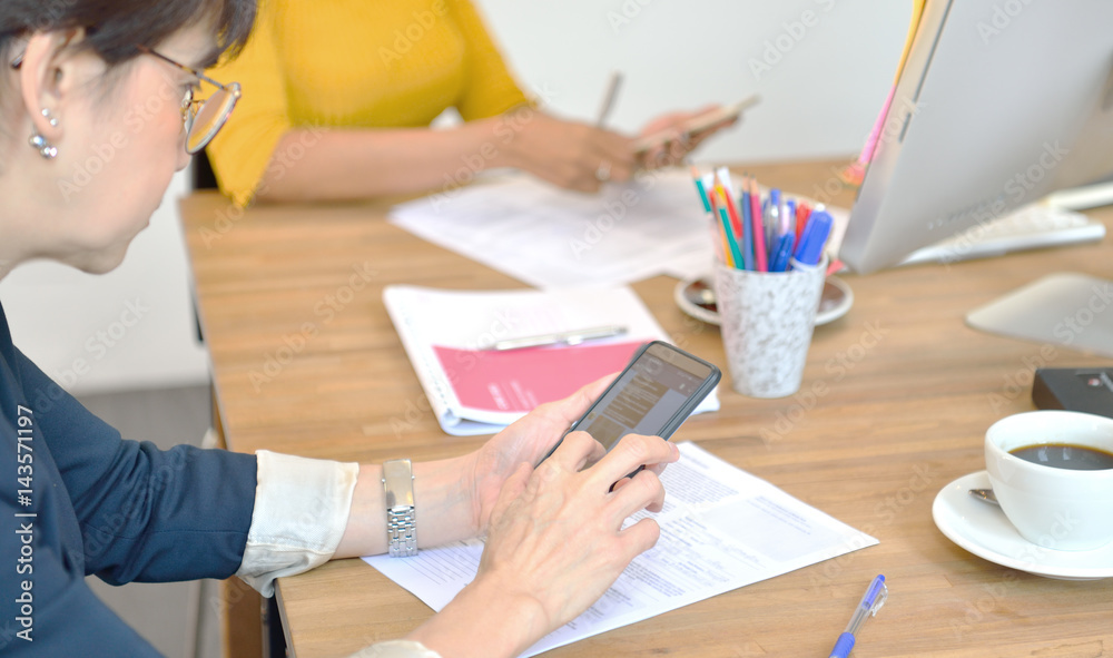 Senior businesswomen using smart phones in the office