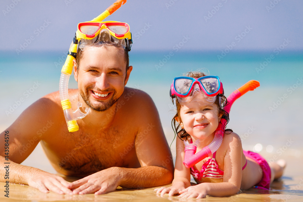 Happy family father and child wearing mask and laughing  on beach