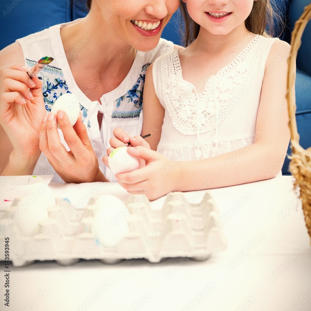 Mother and daughter painting easter eggs