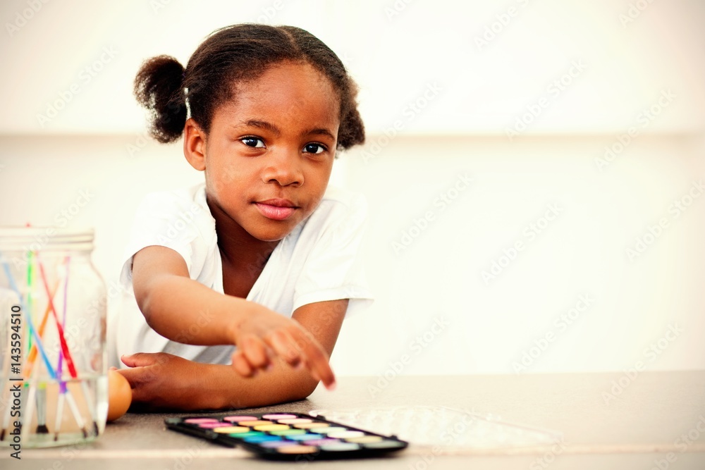 Cute little girl painting eggs in the kitchen