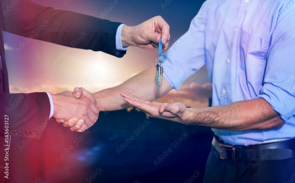 Composite image of businessman shaking hands and giving keys