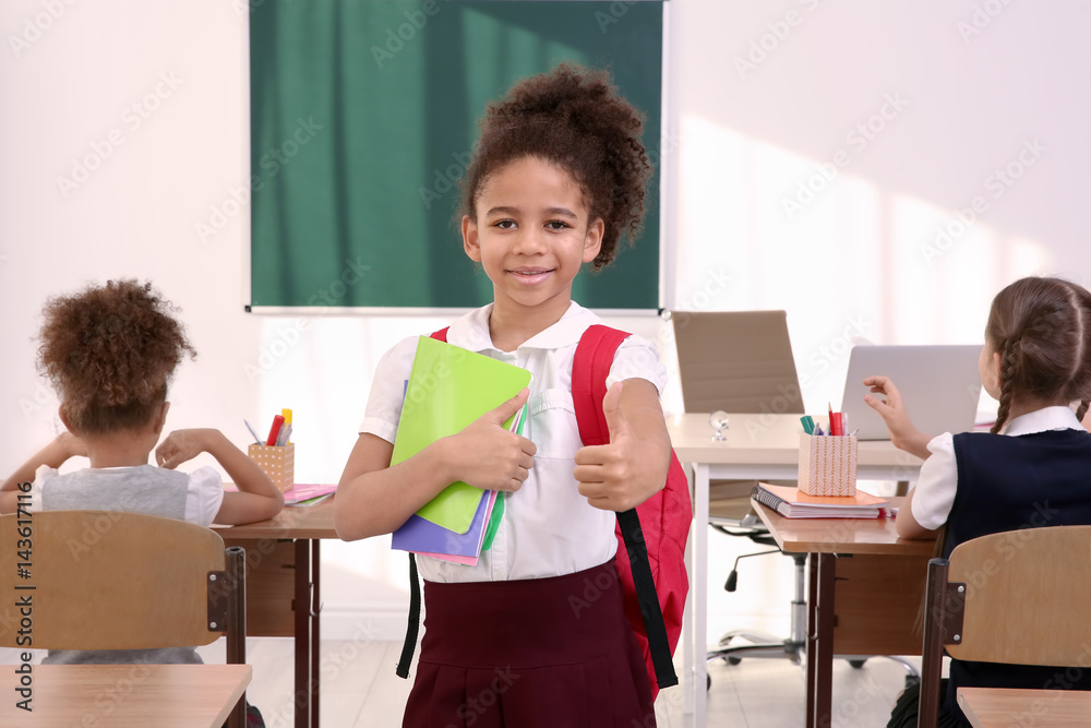 Portrait of beautiful African elementary schoolgirl standing in classroom