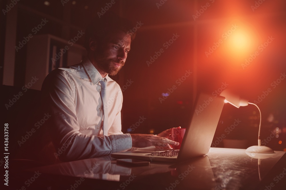 Businessman using laptop at night