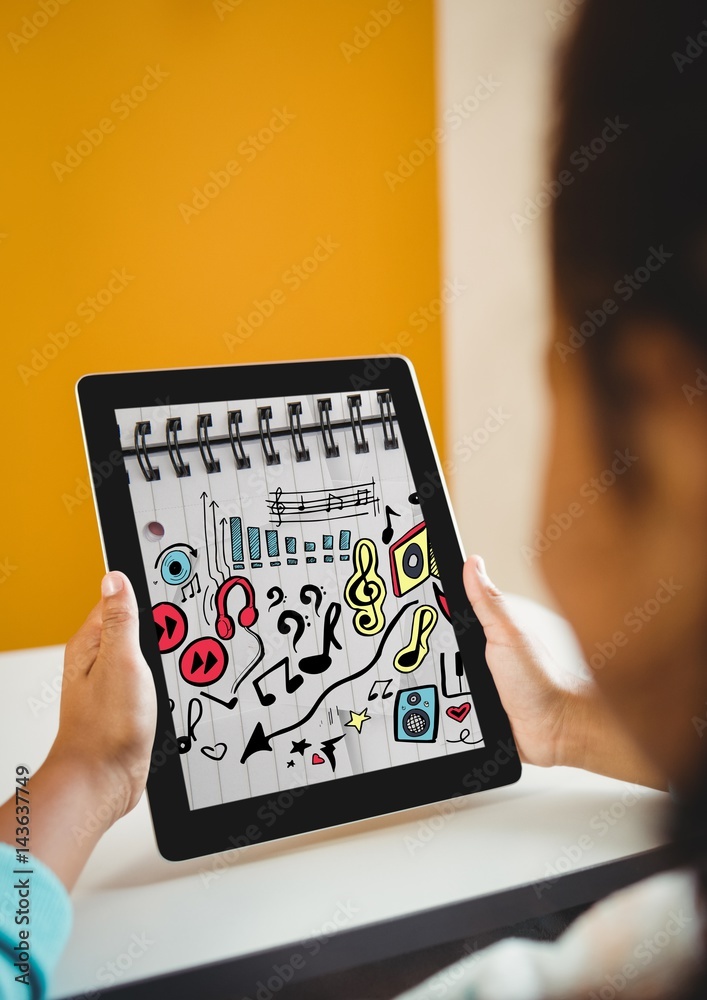 Kid at desk holding tablet showing music doodles on sketchbook