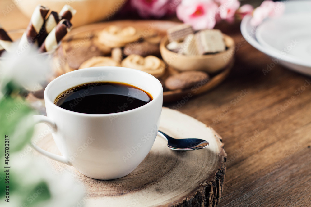 black coffee in white cup with cookie and dessert