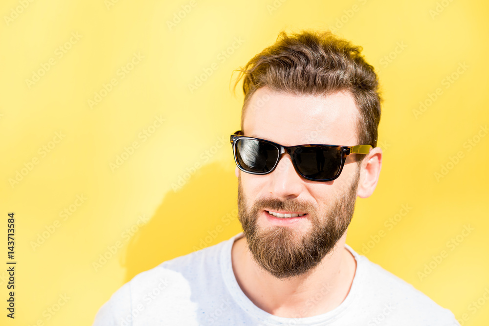 Colorful portrait of a handsome man dressed in white t-shirt on the yellow background