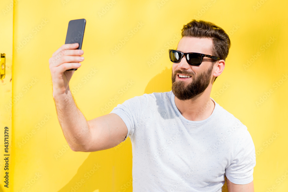 Colorful portrait of a handsome man dressed in white t-shirt on the yellow background