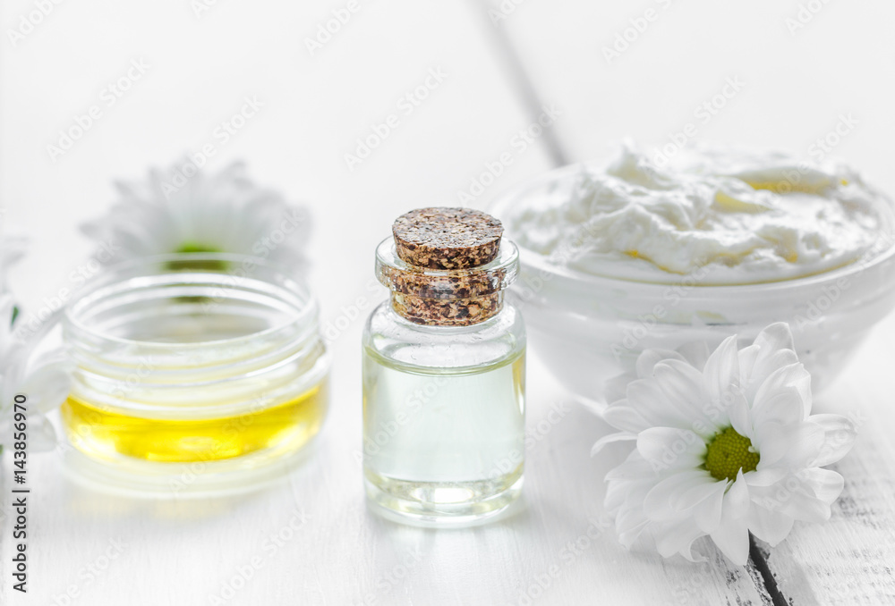 organic cosmetics with camomile extract on wooden table background