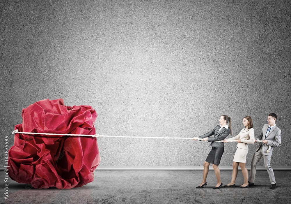 Young business people and huge paper ball as symbol of creativity