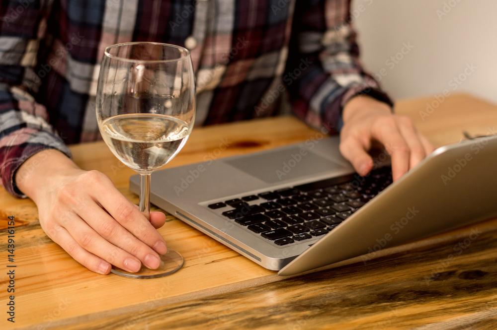 Glass of wine next to laptop