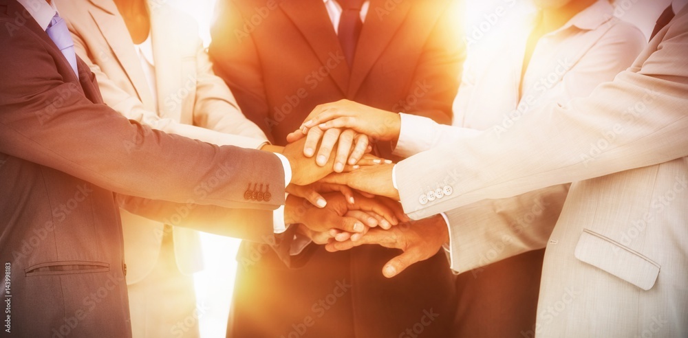 Group of smiling business people piling up their hands together