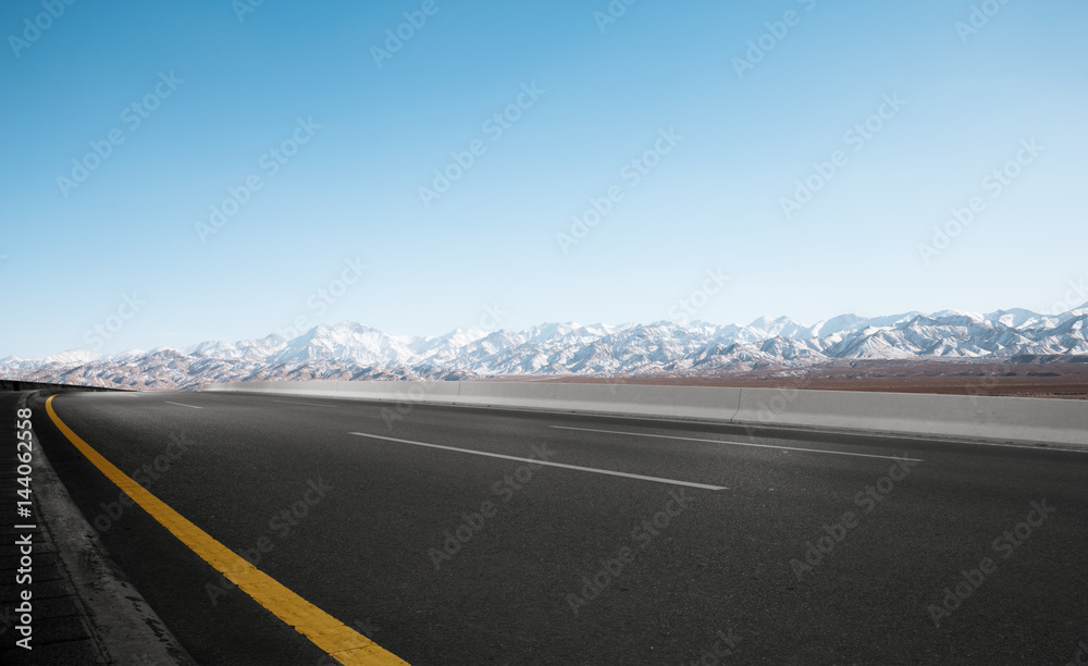 empty road with white snow mountains