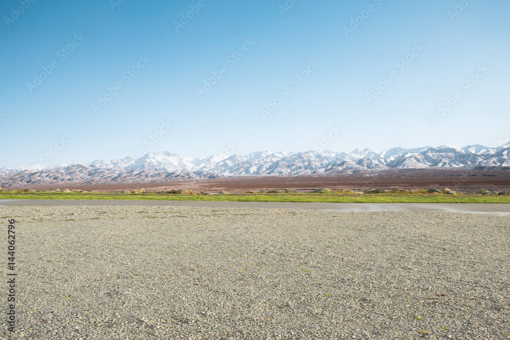 empty ground with white snow mountains