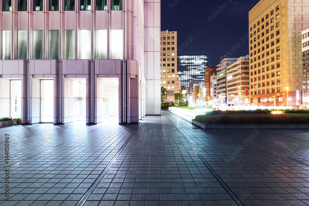 empty footpath outside of modern building at night