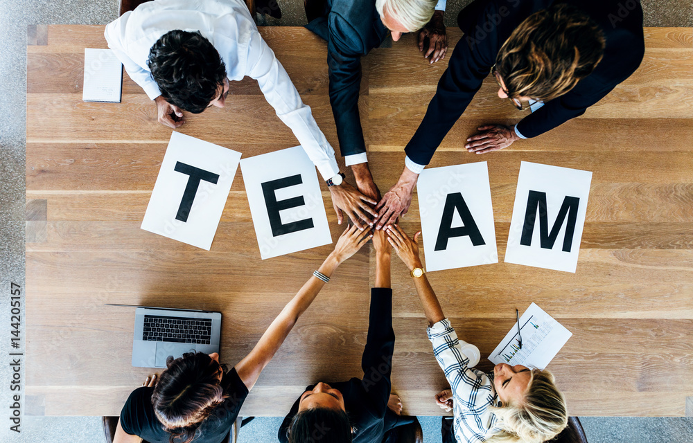 Team word on table with business people stacking hands