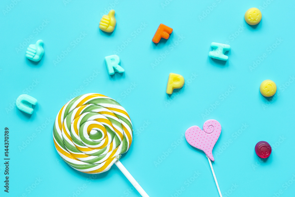 Colorful candies scattered on blue background top view pattern