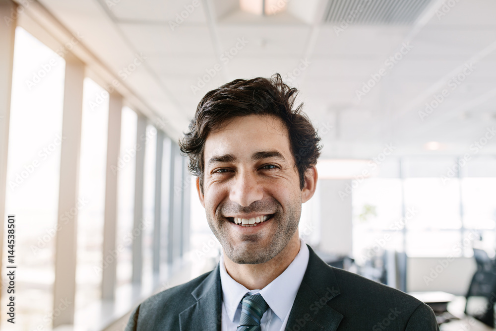 Successful young businessman standing in office