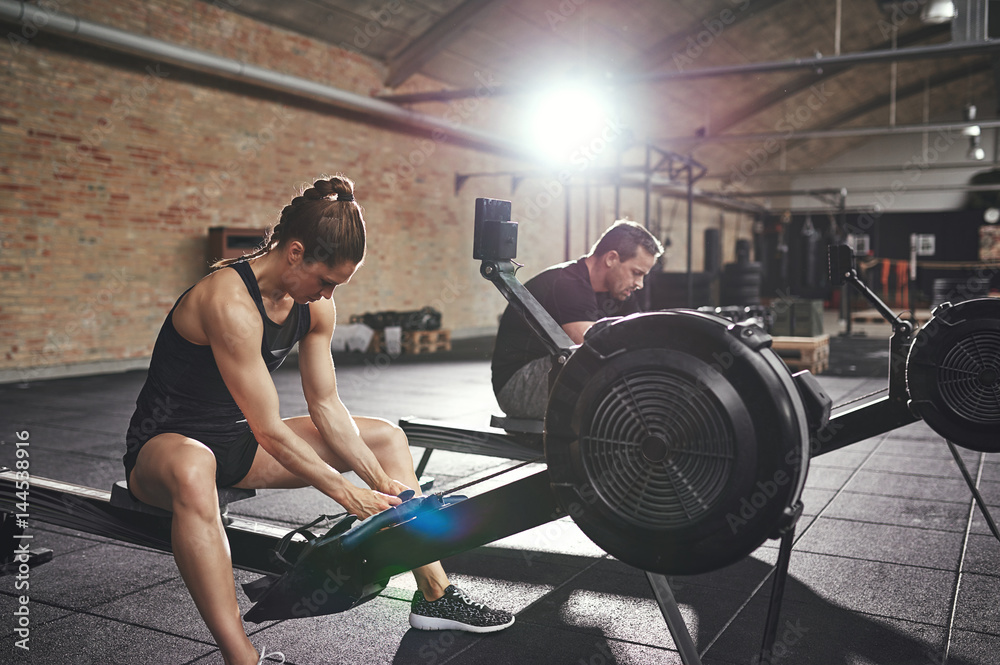 Man and woman training on rowing machines