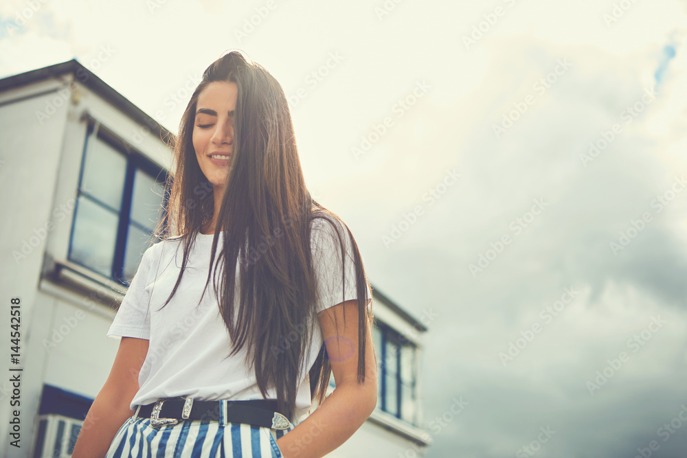 Woman wearing striped pants puts hand in pocket