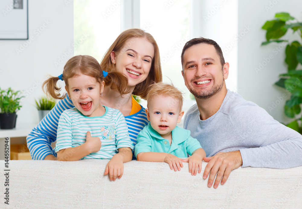 Happy family  laughing and hugging at home on sofa