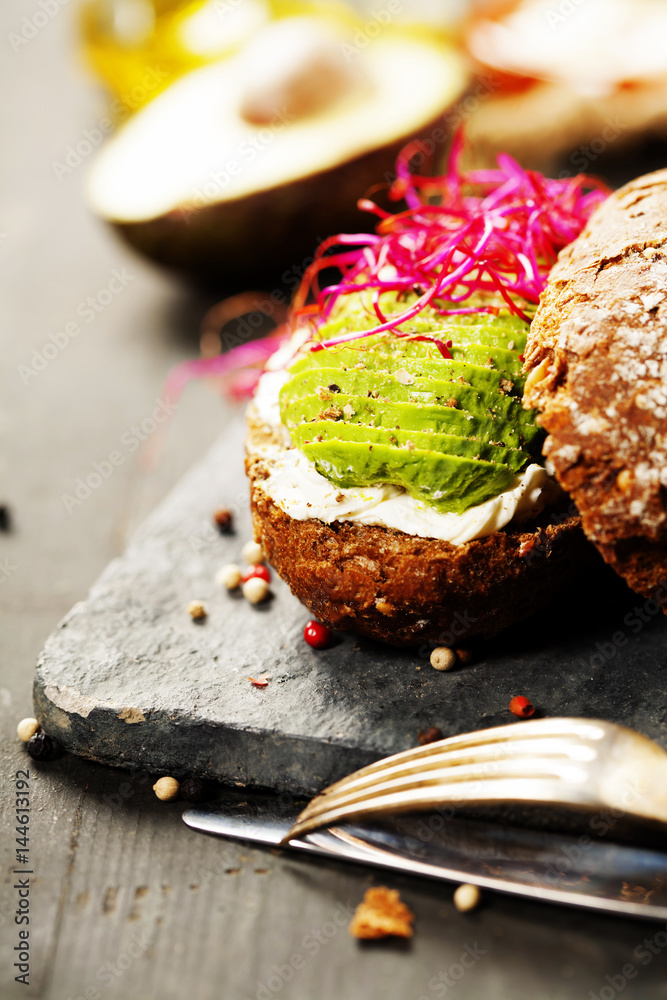 Avocado sandwich on dark rye bread made with fresh sliced avocados