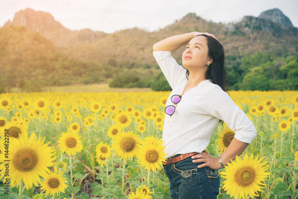 向日葵地里幸福的女人幸福地微笑着