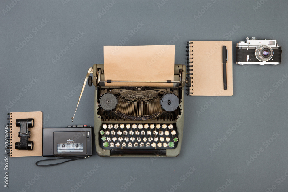 Journalist or private detective workplace - typewriter, camera, recorder and other stuff