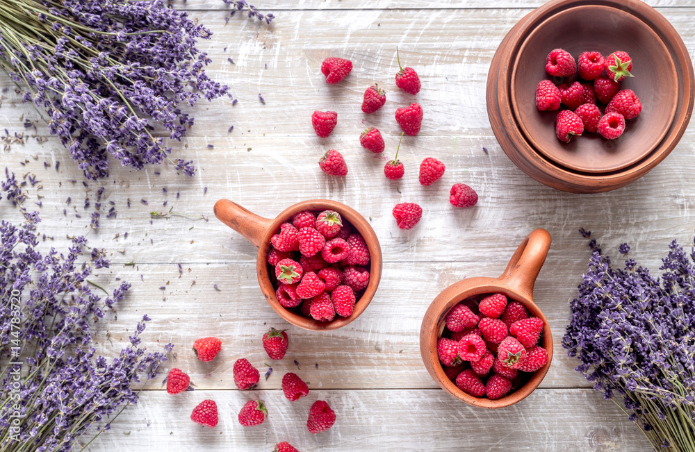 fresh raspberry and dry lavander in rustic design wooden background top view