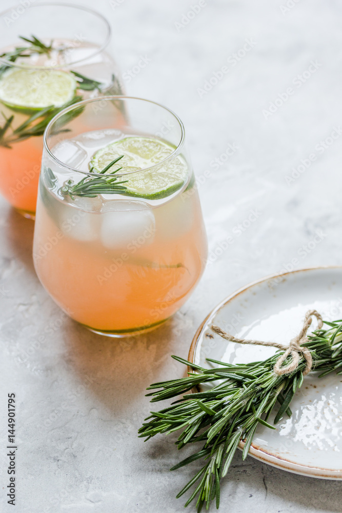 fitness cocktail in glass with lime and rosemary on stone table background