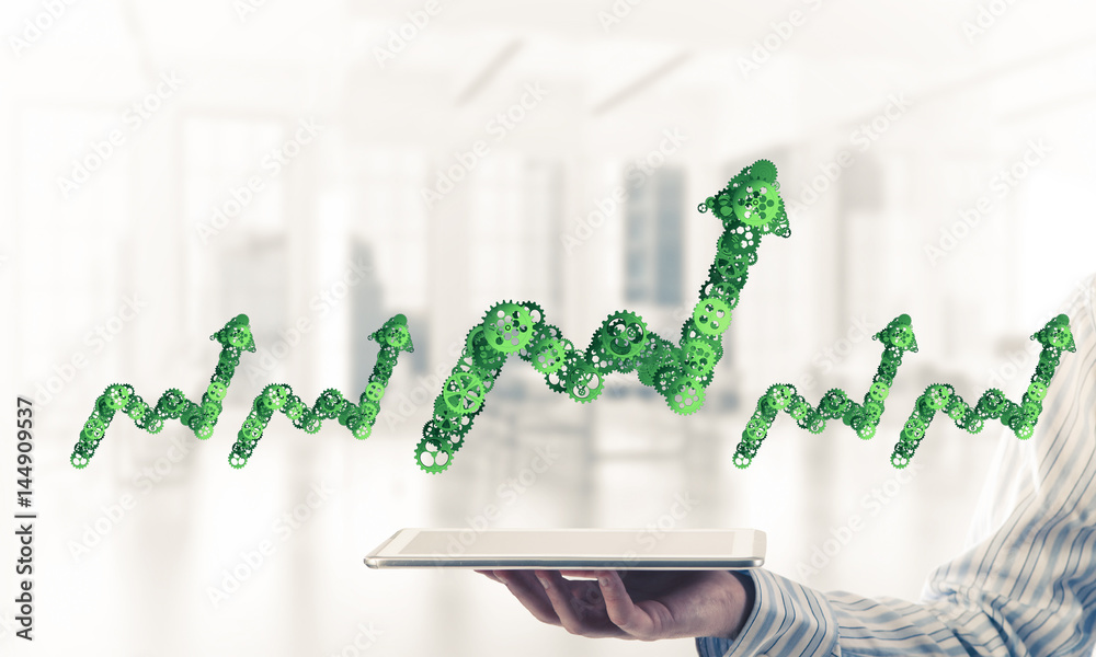 Close of businessman holding tablet pc with progressing graph ic