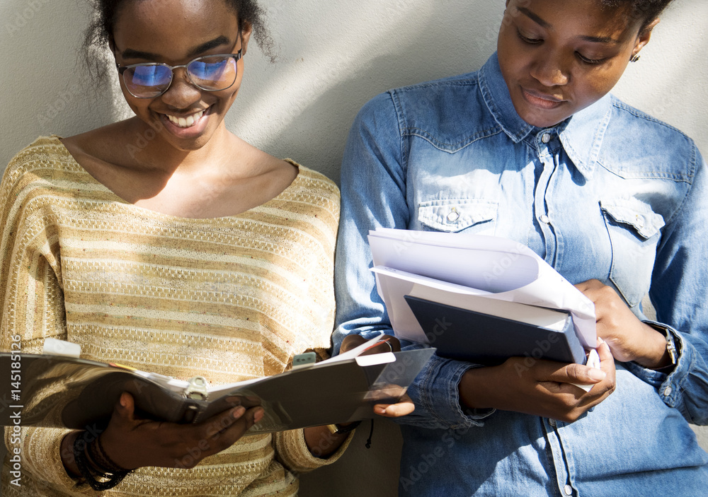 Two african descent girl reading a book