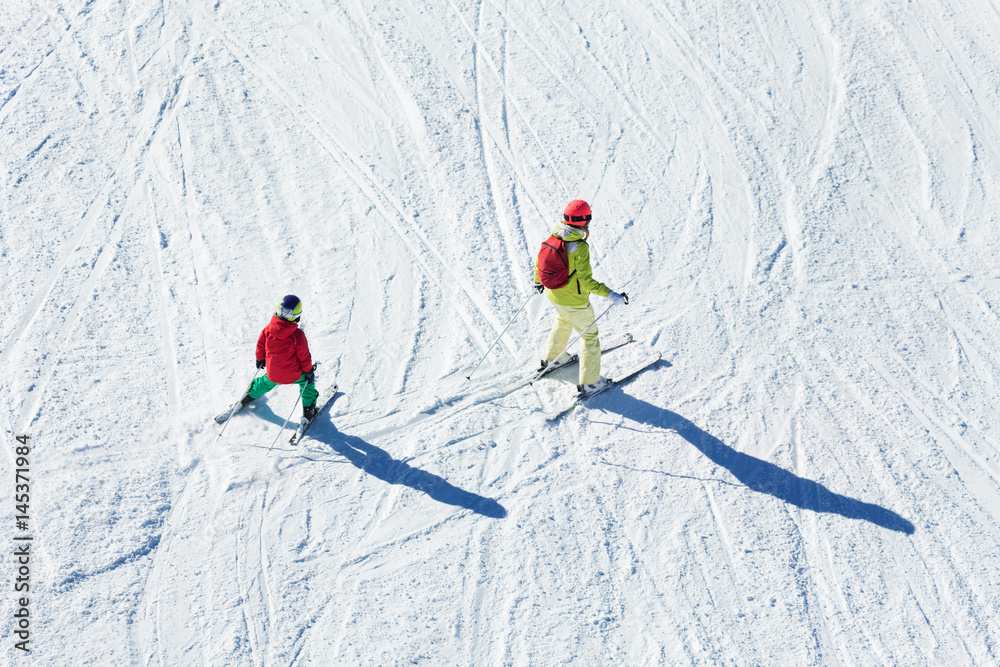 妇女和她的孩子在雪山滑雪