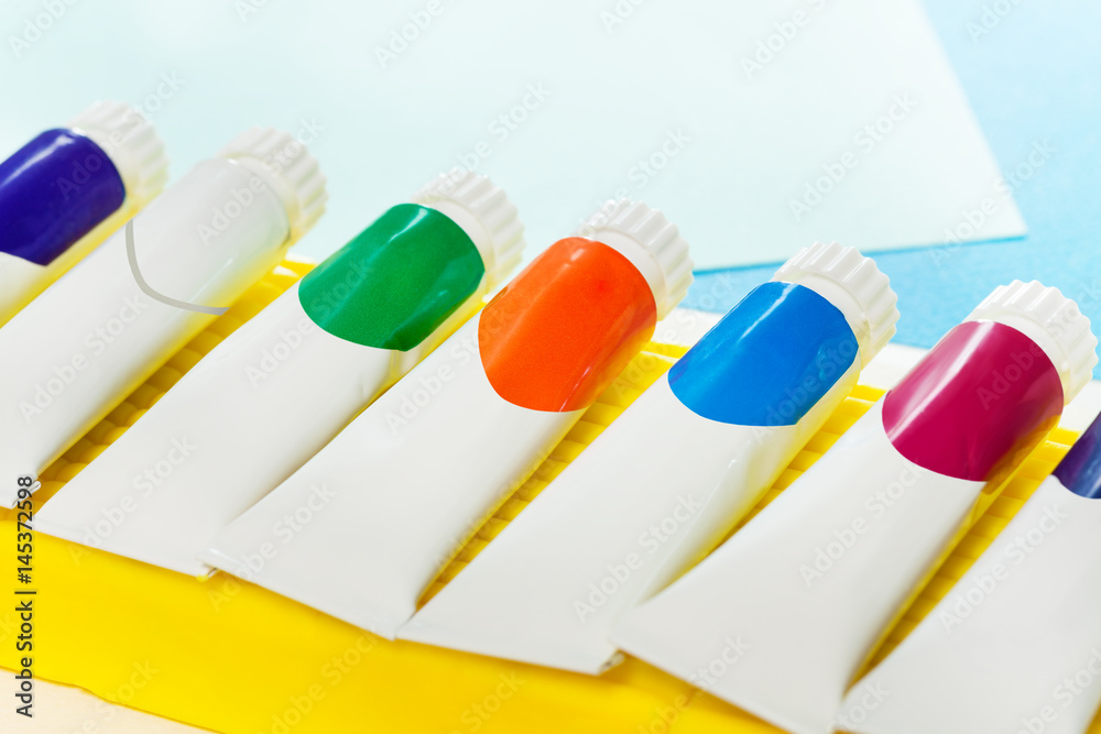 Small tubes of colored gouache laying in a line