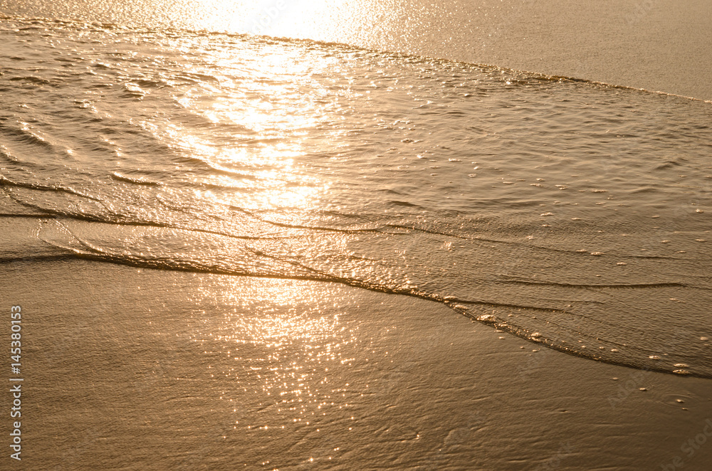 Like liquid gold the setting sun sparkles on the rising tide of Mirimar Beach in Manzanillo, Colima,