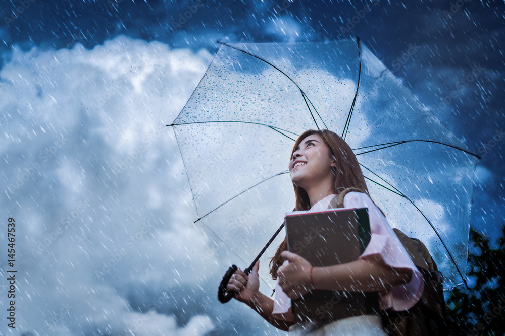 Asian student  waiting for the rain, she had an umbrella.