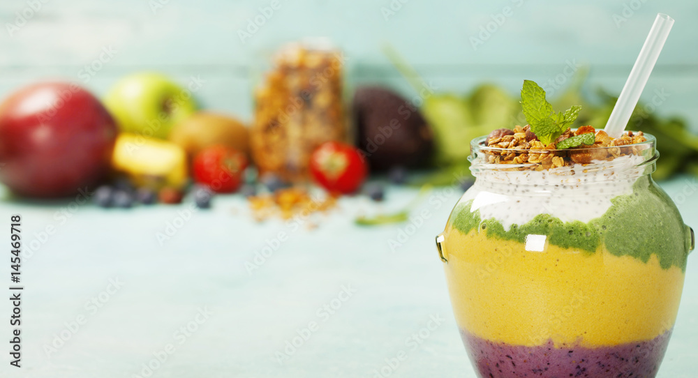 Freshly blended fruit smoothie in glass jar with straw