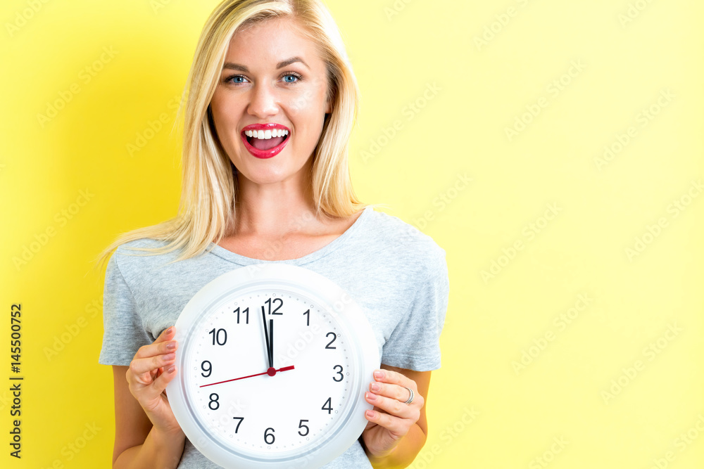  Woman holding clock showing nearly 12