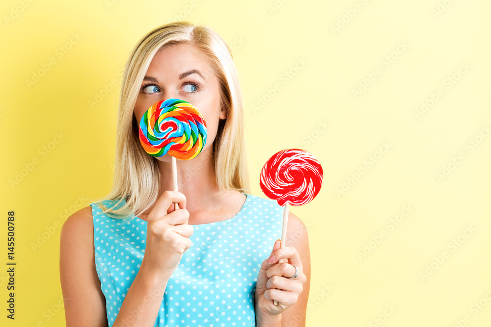 Young woman holding lollipops