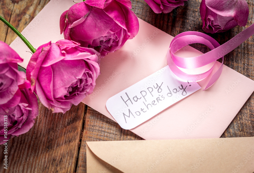 pink peony and greeting-card for Mothers day present on wooden background