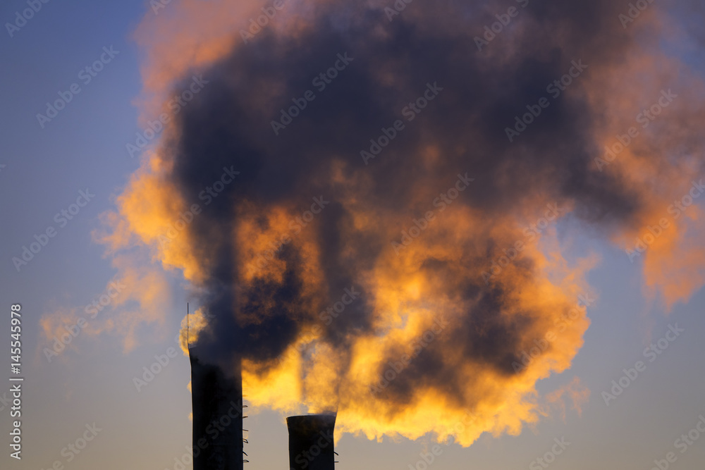 emissions from plant pipe against setting sun