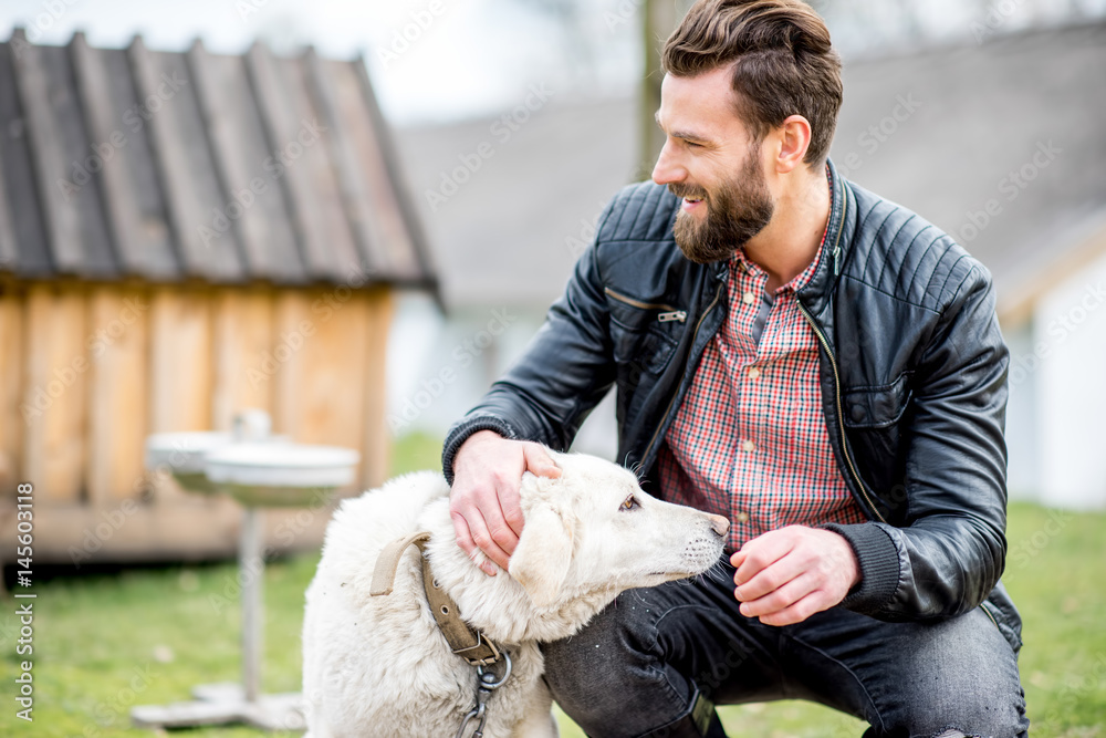 Stylish man with dog outdoors at the household