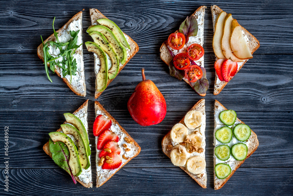 lunch with triangle sandwiches on dark table background top view