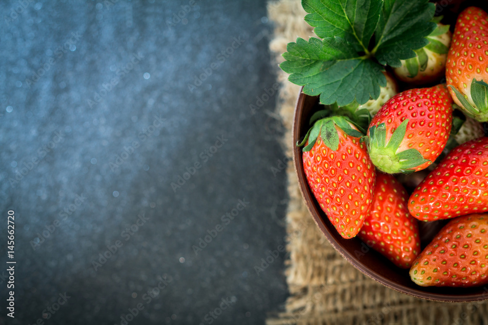 Close up Top view of Red Strawberries and leaf with black stone background