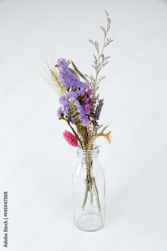 Dried flowers in a bottle isolated on white background