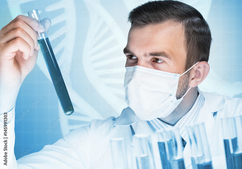 Portrait of concentrated male scientist working with reagents in laboratory