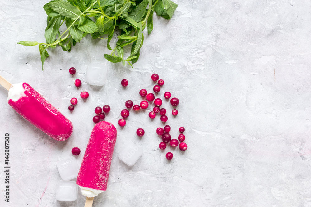 ice, red berries and popsicle stone background top view space for text