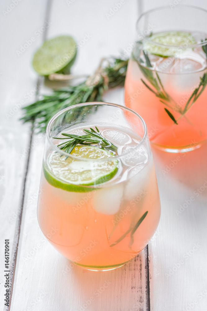 vegetable smoothie with lime and rosemary in glass on white table background