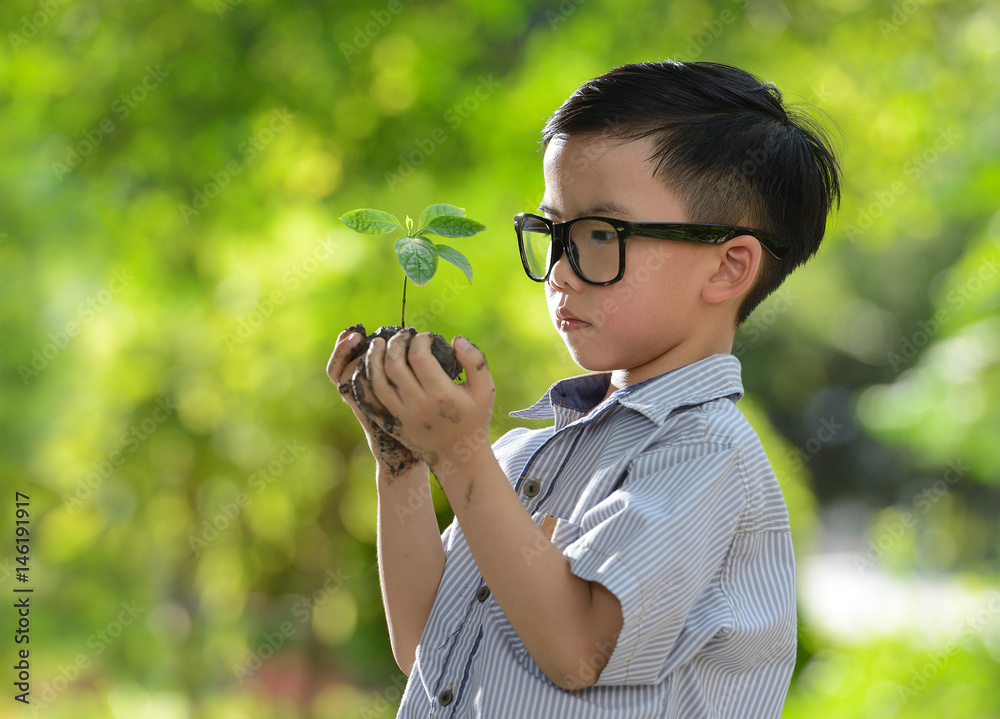 孩子抱着幼小的植物，希望有良好的环境