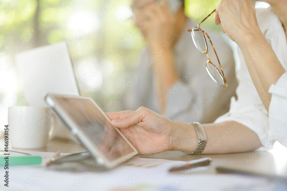 Businesspersons working and using tablet computer in office